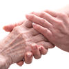 Home assistance Hands of young woman holding the hands of an elderly person